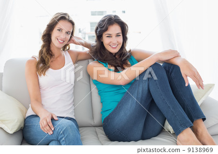 Happy relaxed female friends sitting in living room 9138969