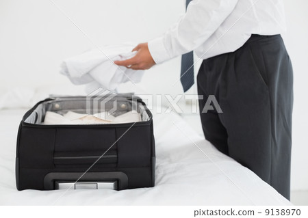 Businessman unpacking luggage at the hotel bedroom 9138970