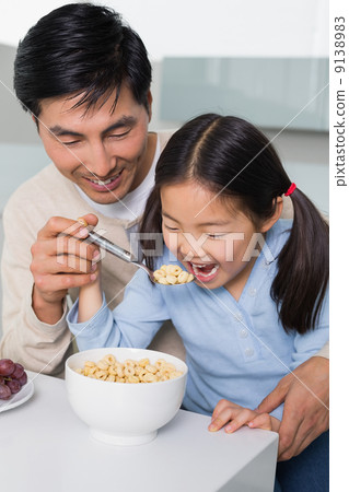 Father with young daughter having cereals in kitchen Father with young daughter having cereals in kitchen 9138983