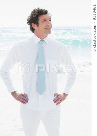 Handsome groom smiling with hands on hips Handsome groom smiling with hands on hips 9139461