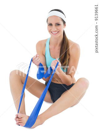 Smiling fit woman exercising with a blue yoga belt 9139661