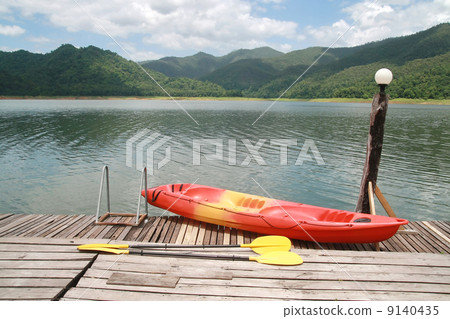 Red kayak with mountain and lake Red kayak with mountain and lake 9140435