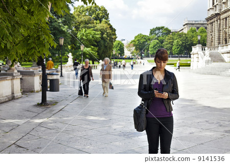 Smart and confident young woman striding through urban area 9141536