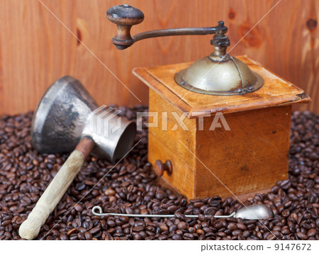 coffee grinder and copper pot on roasted beans 9147672