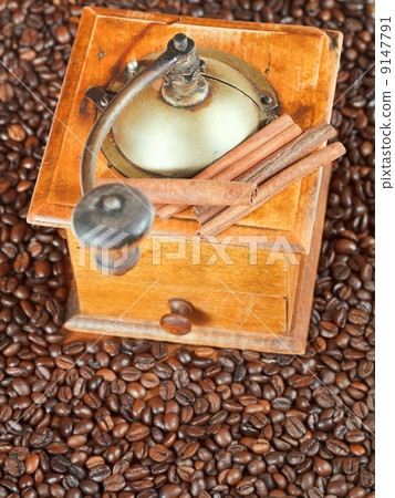 retro manual coffee mill on roasted beans 9147791
