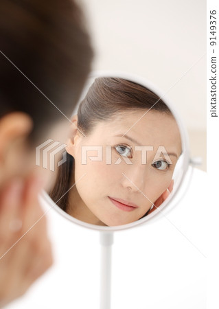 Woman looking in the mirror 9149376