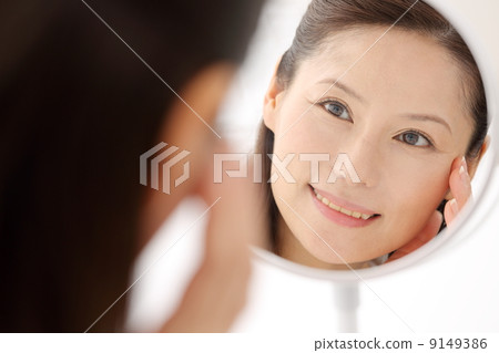 Woman looking in the mirror 9149386