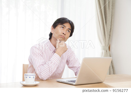 A man looking at a personal computer A man looking at a personal computer 9156277