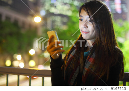 woman use mobile phone in city at night woman use mobile phone in city at night 9167513
