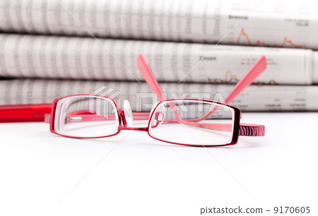reading glasses lie before a big newspaper pile 9170605