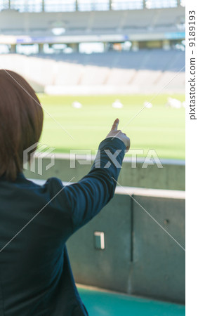 A woman points to the field from the stadium stands. A woman points to the field from the stadium stands. 9189193