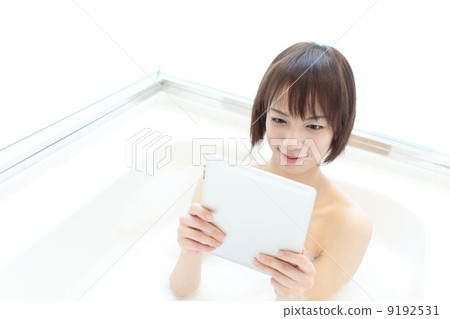 A woman using a tablet in a bath 9192531