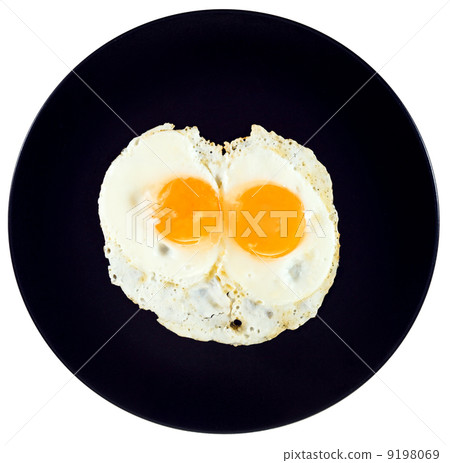 top view of two fried eggs on ceramic black plate 9198069