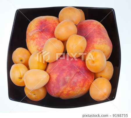 ripe peaches and apricots in black plate 9198735