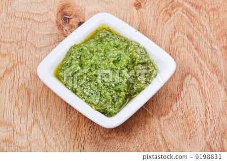 bowl with fresh pesto on wooden board bowl with fresh pesto on wooden board 9198831