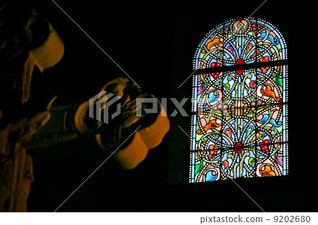 stone cross and stained-glass window in church 9202680