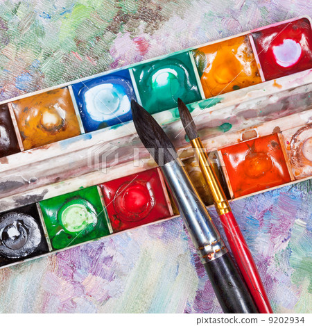 watercolor set and brushes on oil picture background watercolor set and brushes on oil picture background 9202934