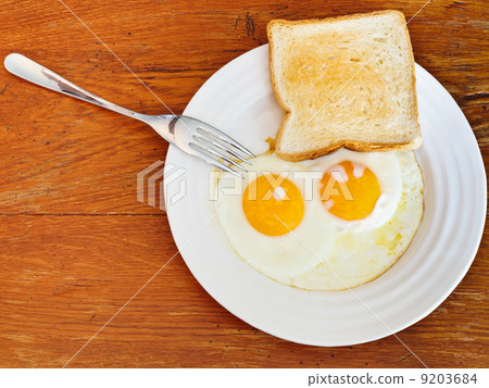 breakfast with two fried eggs in white plate 9203684