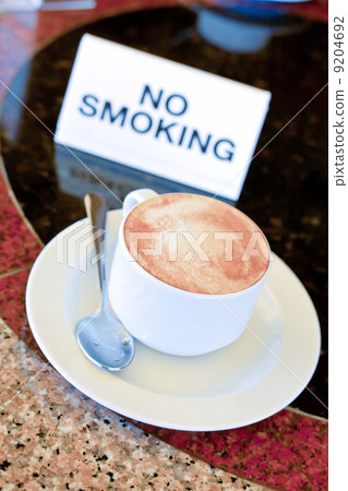 cup of cappuccino on no-smoking table 9204692
