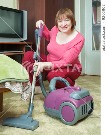 Woman cleaning with vacuum cleaner 9205902