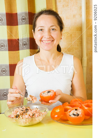 Female cook stuffing tomato 9206025