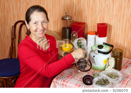 Mature woman brews herbs 9206070