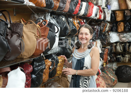 woman chooses leather bag at shop woman chooses leather bag at shop 9206188
