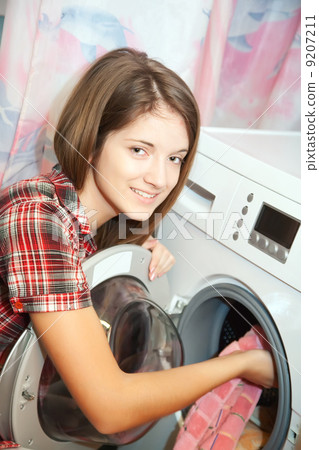 Young woman loading the washing machine 9207211