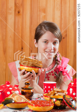 Girl in traditional clothes with pancake 9207235