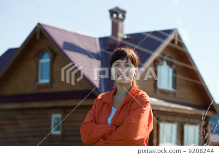 Happy woman against her home 9208244