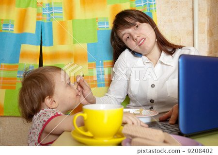 businesswoman feeding baby and speak by mobile 9208402