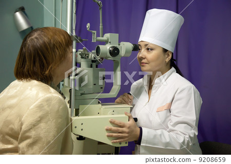 oculist and patient testing eyesight 9208659