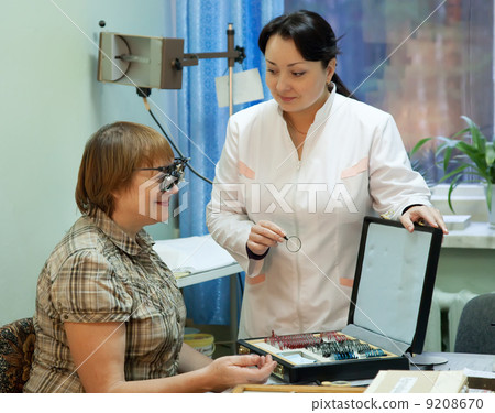 oculist and patient testing eyesight 9208670