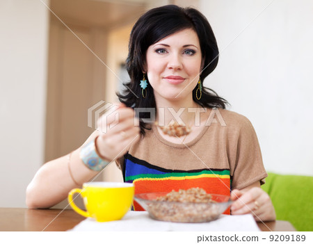woman eats buckwheat cereal woman eats buckwheat cereal 9209189