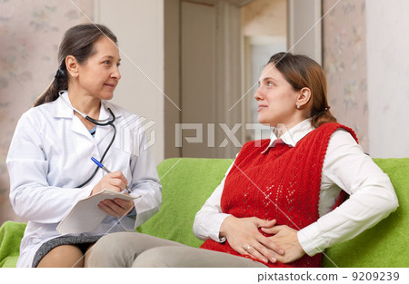 woman complaining of pain in side to doctor woman complaining of pain in side to doctor 9209239