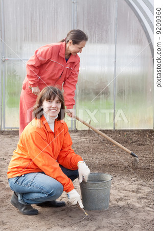 Happy women works at greenhouse Happy women works at greenhouse 9209360