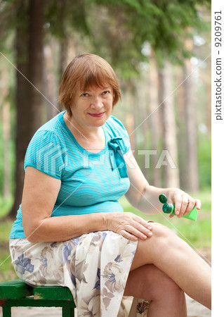 woman embrocating jel in knee woman embrocating jel in knee 9209761