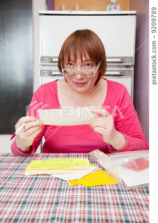 woman with utility bills at her home 9209789
