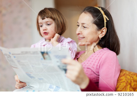 mature woman and child reading newspaper mature woman and child reading newspaper 9210165