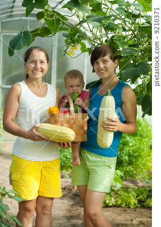 Women and baby with harvested vegetables Women and baby with harvested vegetables 9210371