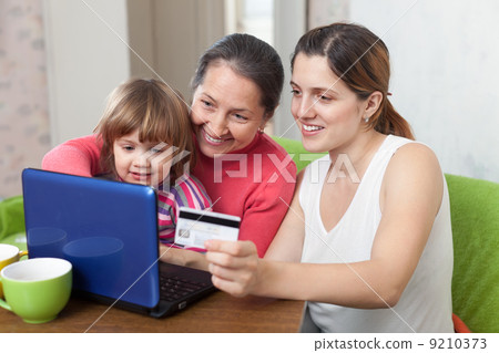 Family of three generations paying by credit card in internet st 9210373