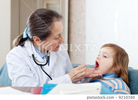 Mature practitioner looks mouth of baby 9210380