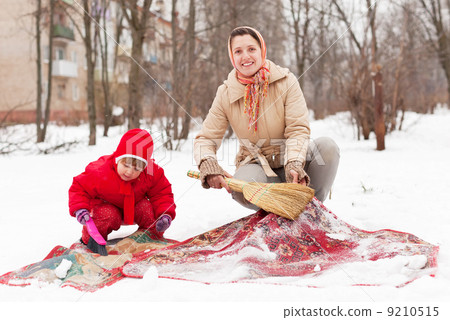 Stock Photo: Family cleans carpet with snow