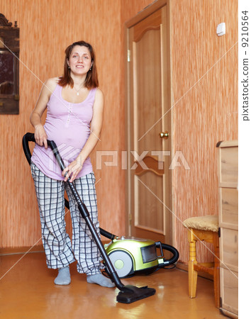 pregnant woman cleaning her living room pregnant woman cleaning her living room 9210564