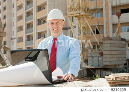 Architect works in front of building site 9210639
