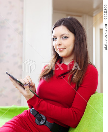 woman in red uses tablet computer or e-book 9210803