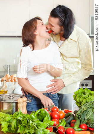 Young man and woman with vegetables in kitchen Young man and woman with vegetables in kitchen 9210927