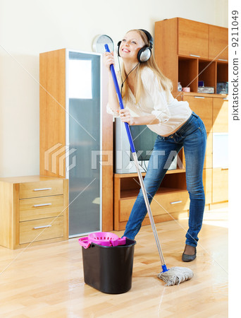 cheerful girl in headphones washing floor cheerful girl in headphones washing floor 9211049