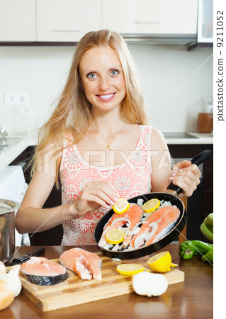 woman cooking salmon with lemon woman cooking salmon with lemon 9211052