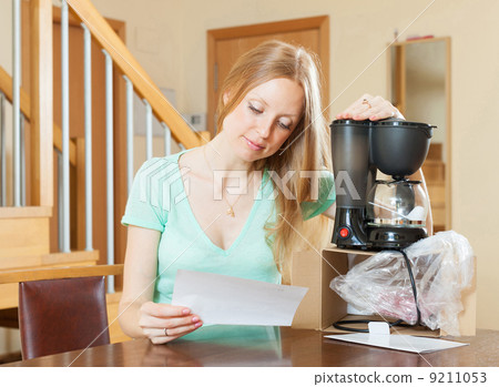 young woman with new coffee machine at home young woman with new coffee machine at home 9211053